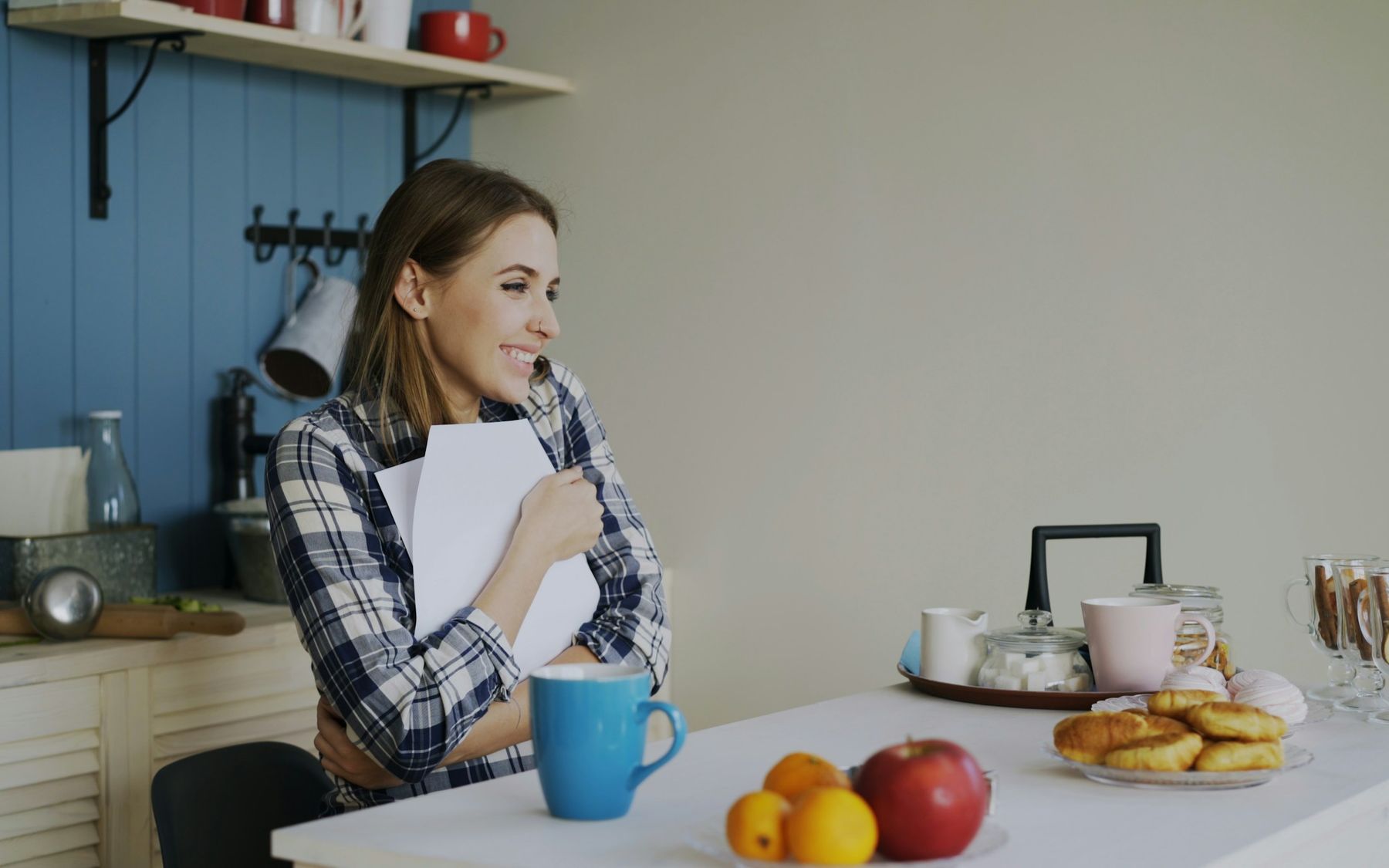 Een vrouw in haar keuken houdt opgelucht een brief vast